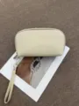 Detail view of the portable leather cosmetic pouch with a wrist strap and smooth zipper closure. - 22*5.5*12CM / Off White