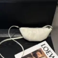 Detalle en primer plano del bolso bandolera cruzado de cuero minimalista en marfil. - Blanco Roto