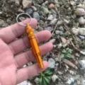 Orange aluminum outdoor survival whistle with waterproof compartment and key ring. - Gold
