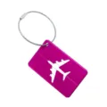 Gros plan sur l'étiquette de bagage en aluminium rose avec découpe d'avion et câble en acier. - Rose rouge