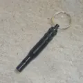 Black aluminum survival whistle with keychain and waterproof compartment for outdoor gear. - Black