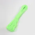 Detailopname van felgroene paracord survivalkabel, netjes opgerold voor buitengebruik nu. - Lichtgevend Groen