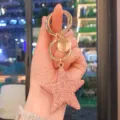 Primo piano dettagliato di un portachiavi a stella in strass rosa con anello dorato. - Rosa