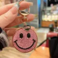Rhinestone smiley face keychain detail view, pink crystal metal bag charm pendant accessorize. - Pink
