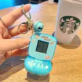 Close-up detail view of a cute blue mini handheld game console keychain with cute space bear design. - Blue