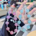 Close-up of sparkling pink and blue crystal beaded phone charms and bag chain pendants. - Blue Beads
