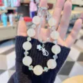 Close-up detail shot of crystal beaded phone charm strap with pearlescent beads and star. - Beige Beads