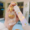 Clear resin unicorn keychain detail view, holographic strap with gold hardware charm. - Transparent White Unicorn