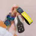 Resin iridescent unicorn keychain detail, showing shiny rainbow pendant and stylish strap close-up. - Black Multicolor Unicorn