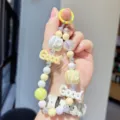 Colorful beaded phone strap detail, cute yellow macrocaron charm keychain accessory. - Yellow
