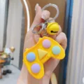 Vista dettagliata del portachiavi giocattolo antistress gamepad giallo con bottoni colorati. - Giallo