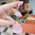 Primo piano dettaglio del simpatico portachiavi maialino rosa in resina con ciondolo paperella. - Maiale Papera Gialla