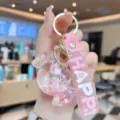Cute acrylic quicksand candy keychain with oil-filled doll, perfect bag charm for girls. - Pink