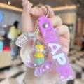 Closeup of cute acrylic quicksand candy keychain showcasing the purple silicone strap and liquid. - Purple