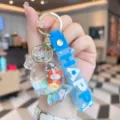 Cute acrylic quicksand candy keychain detail showing transparent bottle and blue happy strap. - Blue