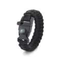 Detailed view of black paracord survival bracelet with compass and emergency whistle. - Black
