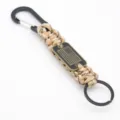 Detailed close-up view of tactical paracord keychain with metal carabiner and flag tag. - Desert Camo