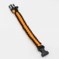 Black and orange paracord survival bracelet detail, durable outdoor gear with plastic buckle. - Orange and Black