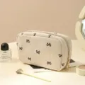 Minimalist beige corduroy makeup bag with cute black bow pattern, portable travel cosmetic pouch. - Bee Cream