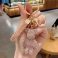 Detail view of a sparkling rhinestone bear keychain, elegant crystal bag charm accessory. - Pink