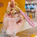 Pink jelly bear keychain detail shot with rhinestones, gold hardware, and braided strap - Pink