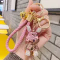 Dettaglio portachiavi coniglio rosa metallizzato, orecchie in strass e cinturino intrecciato - Rosa