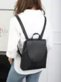 Detail view of the black genuine leather backpack worn on model, showing the back design. - 25*10*31CM / Black