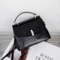 Black crocodile pattern handbag detail, stylish top handle design for women fashion. - Black