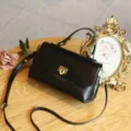 Black genuine leather retro shoulder bag detail showing premium texture, lock and strap. - Black