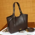 Vista detallada del bolso tote de cuero marrón oscuro con textura y elegante detalle metálico. - Chocolate