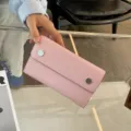 Nahaufnahme der rosa Lederhandytasche mit Palmmaserung und stylischen Metall-Druckknöpfen. - 19*11.5*4.5CM / Rosa