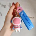 Leuke cartoon astronaut sleutelhanger met blauwe band, perfecte tas en autosleutel accessoire. - Roze Ruimtevaarder