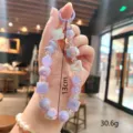 Close-up detail of cute purple acrylic beaded keychain and bracelet with lovely charms and pastel tones. - Cheese Beaded / Cheese Beaded - Purple