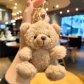 Plüsch Teddybär Schlüsselanhänger Detail, weiches braunes Fell mit goldenem Metallring. - Plüschbär - Grau
