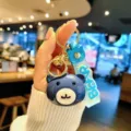 Cute blue bear keychain detail view, acrylic doll pendant with gold metal ring and strap. - Blue