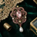 Close-up detail shot of vintage baroque style brooch with sparkling pink rhinestones and pearl. - Pink Teardrop Main Stone Style (XD826066-1)