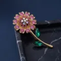 Elegant gold tone flower brooch with sparkling pink rhinestones and green crystal leaves for women. - Gold Pink Rhinestone Iridescent Center Green Leaf Flower Style (823058)