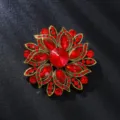 Dettaglio della spilla a fiore con strass rossi, gioiello in lega color oro antico. - Stile Fiore Rosso (XD825545-4)