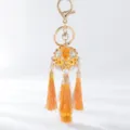 Close-up detail of the elegant orange rhinestone hydrangea keychain with vibrant tassels. - Yellow Hydrangea
