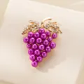 Detalle broche uva perla, aleación dorada con pedrería brillante en las hojas. - Purpura Perla Artificial Uva