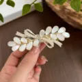 Elegant gold spring hair clip featuring white cat eye stones, pearls and sparkling rhinestones. - Leaf Bow Spring Clip / Gold