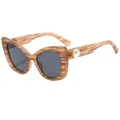 Chique cat-eye zonnebril voor dames met bruin zebramotief en pareldecoratie op de pootjes. - Houtnerf Frame Grijze Lens