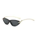 Gafas de sol de ojo de gato negras elegantes con patillas doradas y detalle de nudo. - Montura Negra Lentes Grises