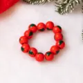 Detailed close-up of red wooden beaded bracelet featuring green Christmas tree prints on plush. - Christmas Tree Pattern (SG356-6) / Red