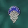 Detail van blauwe kristallen kwal broche, sprankelende strass steentjes kwast. - Blauw