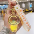 Close-up detail of the clear acrylic liquid floating glitter bear keychain with lucky strap. - Yellow