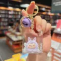 Lusinghiero portachiavi con sabbia mobile in acrilico con statuetta viola e campanello. - Viola