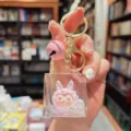 Cute pink plush doll acrylic quicksand keychain with gold hardware and bell pendant. - Pink