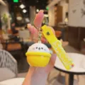 Detailed closeup of cute cartoon puppy silicone keychain featuring yellow strap and metal ring. - Yellow