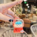 Cute liquid quicksand keychain with a lovely cartoon doll figure, perfect bag pendant charm. - Glitter Red